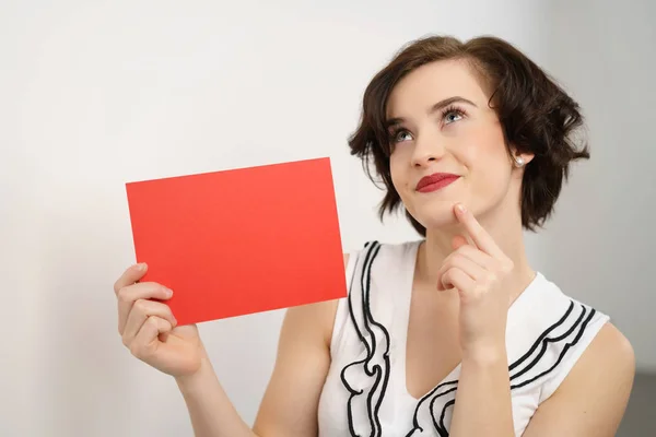 Mladá žena držící prázdné červené znaménko — Stock fotografie