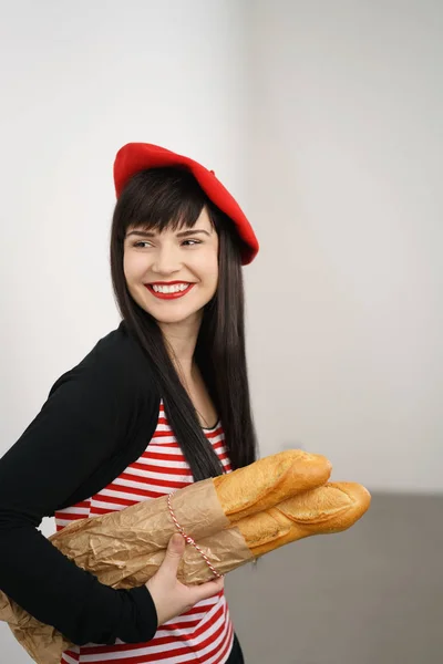 Feliz joven francesa bonita llevando baguettes — Foto de Stock