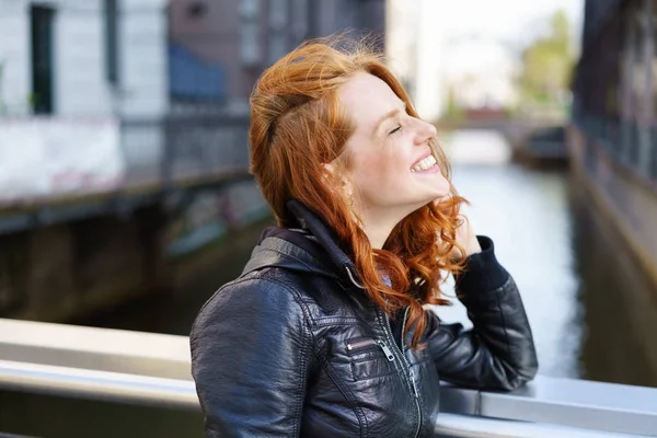 Happy carefree young woman relaxing on a bridge — Stock Photo, Image