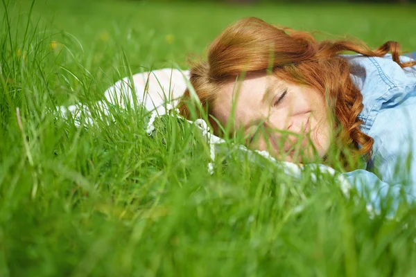 Giovane donna addormentata su fresca erba verde primavera — Foto Stock
