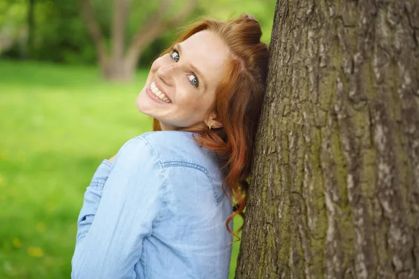 Glada naturliga ung kvinna i en spring park — Stockfoto