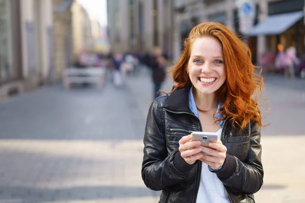 Heureuse femme amicale en utilisant son mobile à l'extérieur — Photo