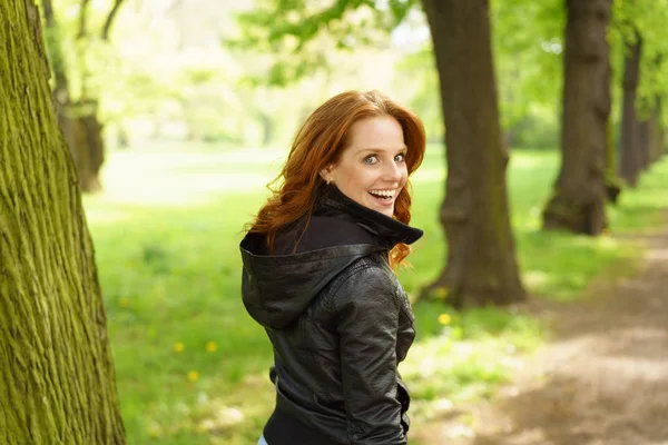 Niedlich lachende junge Frau schlendert durch einen Park — Stockfoto