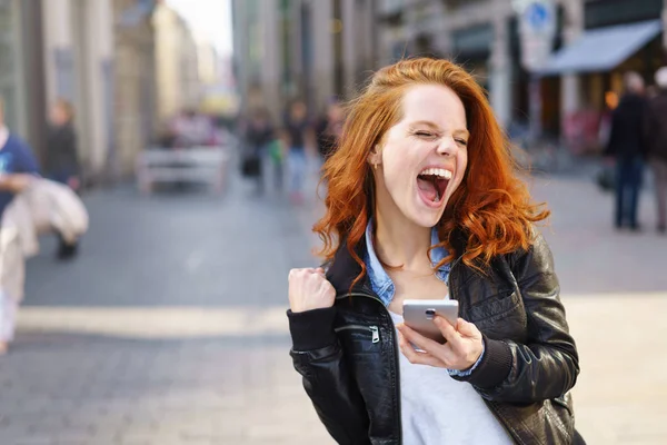 Exuberant young woman cheering at good news — Stock Photo, Image
