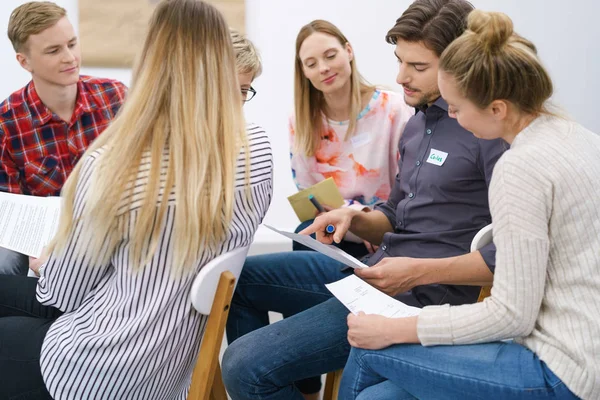 Studenti seduti in gruppo che discutono note di classe — Foto Stock