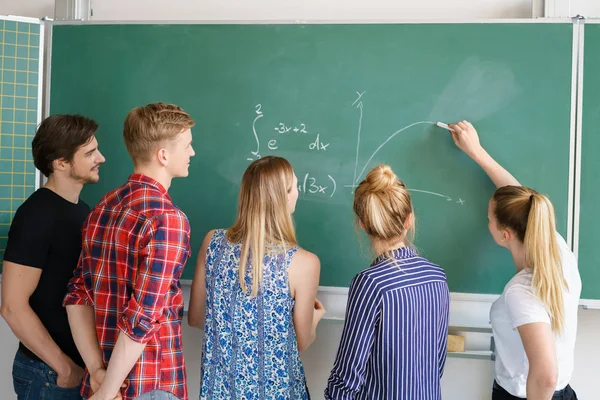 Gruppo di studenti che lavorano su un problema di matematica — Foto Stock