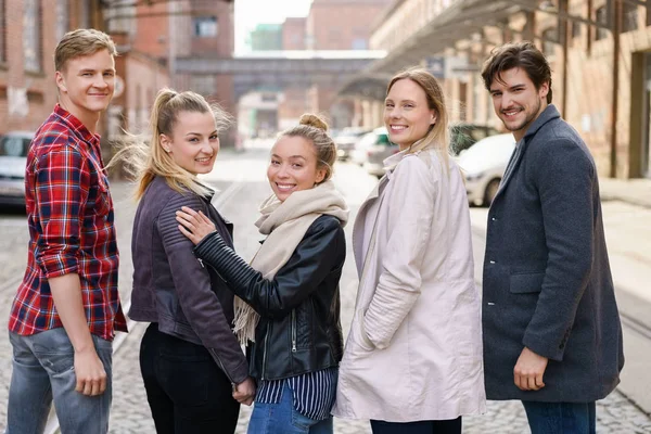 Group of young adults standing in a street — Stock Photo, Image