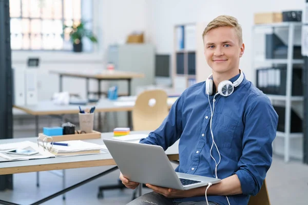 Young man listening to music in the office — Stock Photo, Image