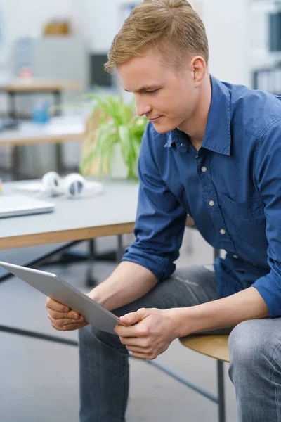 Jungunternehmer liest auf seinem Tablet-PC — Stockfoto