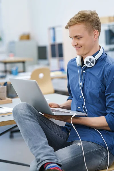 快乐的年轻人，在他的笔记本电脑上听音乐 — 图库照片
