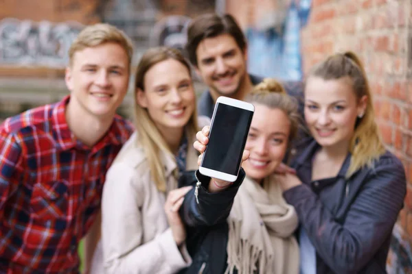 Ομάδα ευτυχής χαμογελαστοί φοιτητών κρατώντας ένα κινητό — Φωτογραφία Αρχείου