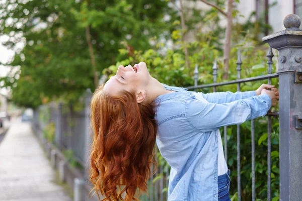 Giocoso giovane rossa donna appesa ad una recinzione — Foto Stock