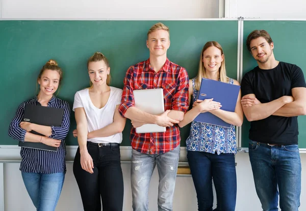 Gruppe junger Studenten posiert im Klassenzimmer — Stockfoto