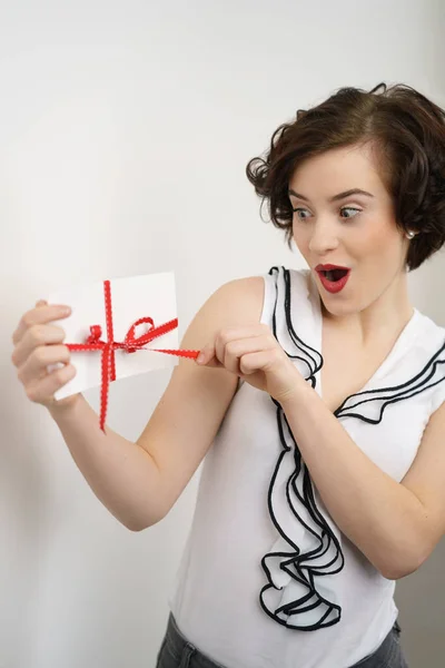 Excited young woman opening a gift — Stock Photo, Image