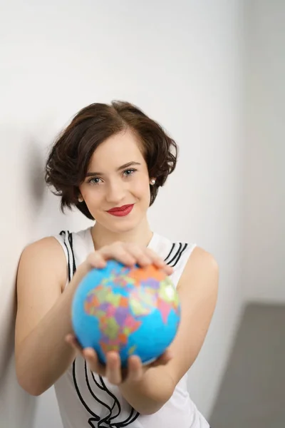 Гарненька молода жінка тримає світову кулю — стокове фото