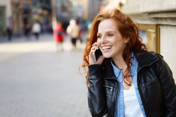 Mujer joven y feliz hablando en su celular — Foto de Stock