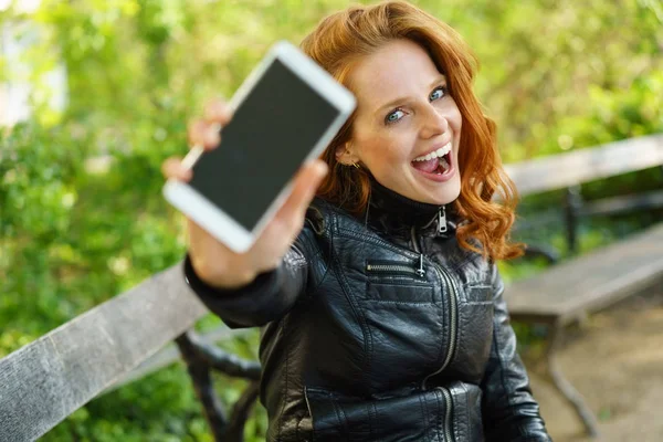 Riendo mujer feliz mostrando su móvil —  Fotos de Stock