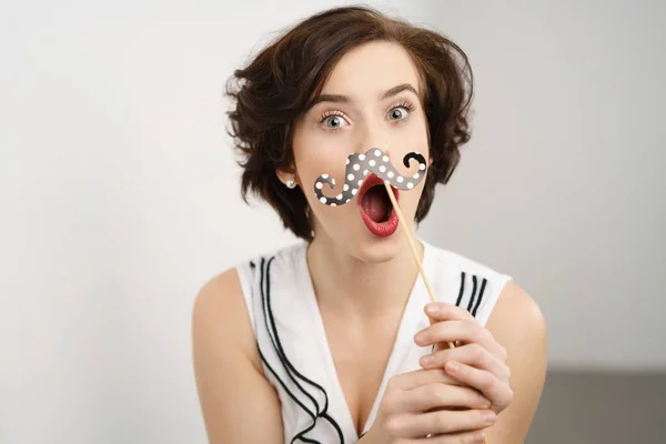 Mischievous young woman with a party accessory — Stock Photo, Image