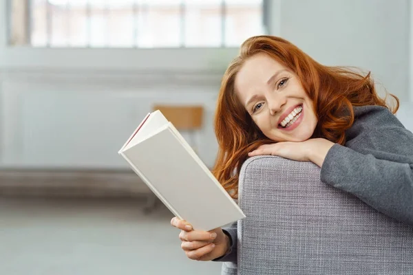 Wesoła, młoda kobieta, ciesząc się książki w domu — Zdjęcie stockowe