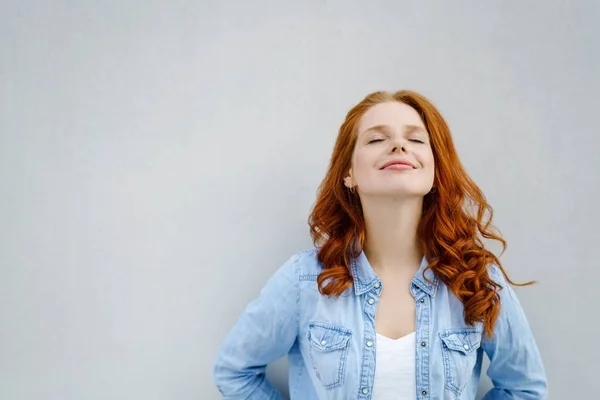 Mujer joven relajándose con una sonrisa dichosa —  Fotos de Stock