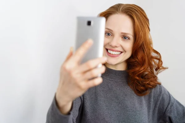 Zufriedene junge Frau grinst eine SMS an — Stockfoto