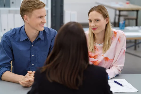 Young couple in a meeting with a broker or agent — Stock Photo, Image