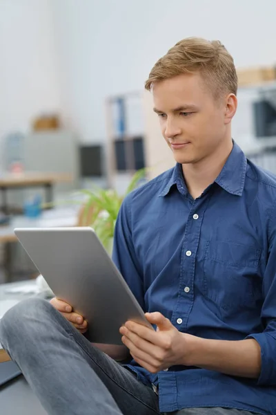 Joven hombre de negocios leyendo en su PC tableta — Foto de Stock