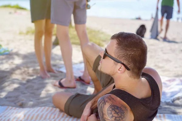 Νεαρός Άνδρας Τατουάζ Χαλαρώνοντας Στην Παραλία — Φωτογραφία Αρχείου