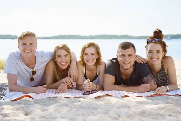 Studenti che si rilassano su una spiaggia sabbiosa — Foto Stock