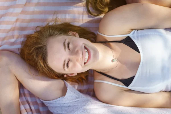 女人躺在毛巾上享受阳光的朋友 — 图库照片