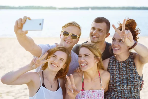 Jóvenes amigos tomando una selfie en la playa —  Fotos de Stock