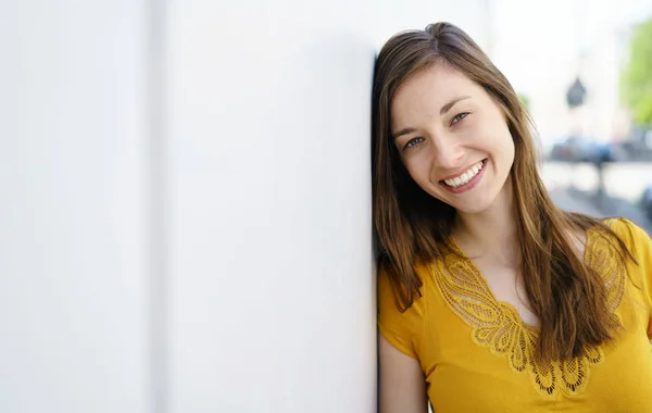 Duvar yanındaki gülümseyen kız — Stok fotoğraf