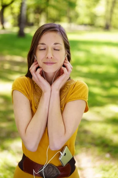 Genç kadın bir parkta onun müzik keyfi — Stok fotoğraf