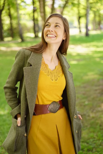 Ganska glad ung kvinna promenader i en spring park — Stockfoto