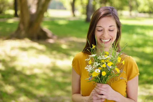 Ung kvinna som håller en enkel bukett av blommor — Stockfoto