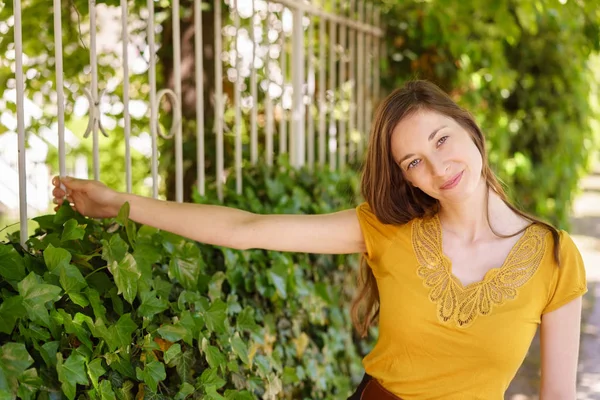 Thoughtful young woman holding an iron railing — Stock Photo, Image