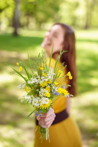 笑着年轻女子提供一束花 — 图库照片