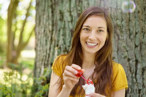 Fille gaie avec ventilateur à bulles dans le parc — Photo