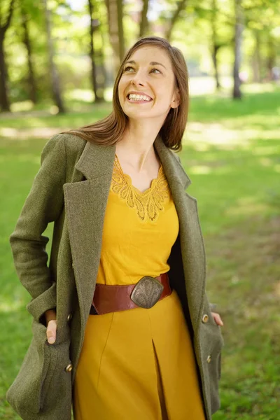 Mujer joven bastante feliz caminando en un parque de primavera —  Fotos de Stock