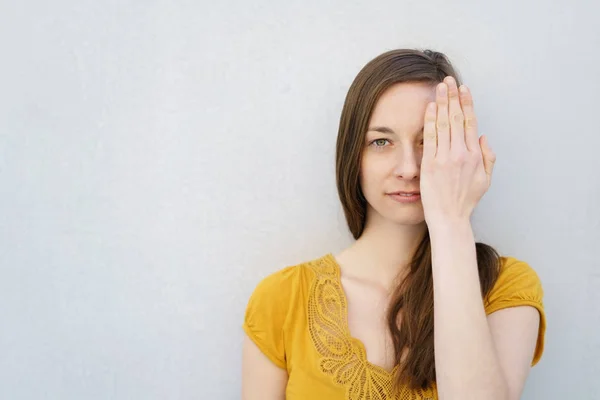 Grave giovane donna che copre un occhio — Foto Stock