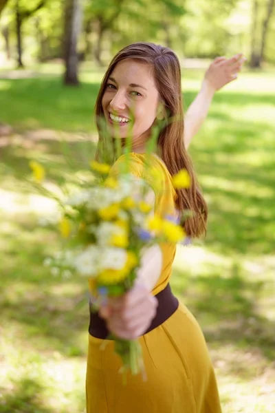 Young woman dancing with a bunch of flowers — Stock Photo, Image