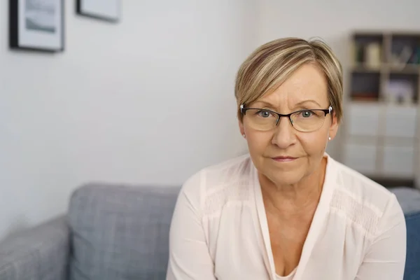 Seniorin sitzt auf Sofa — Stockfoto