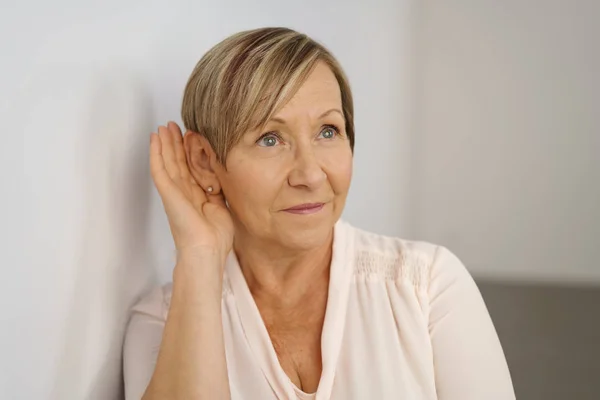 Senior vrouw leningen van haar oor — Stockfoto