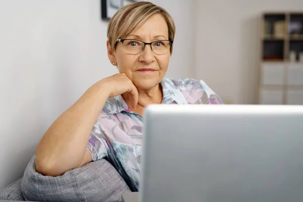 高级的女人坐在笔记本电脑前 — 图库照片