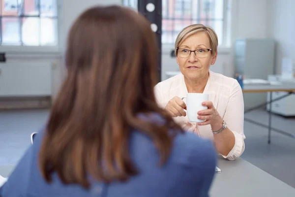 Twee vrouwen zitten aan de balie in kantoor — Stockfoto