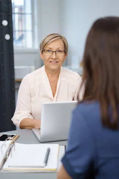 Senior businesswoman talking to a colleague — Stock Photo, Image