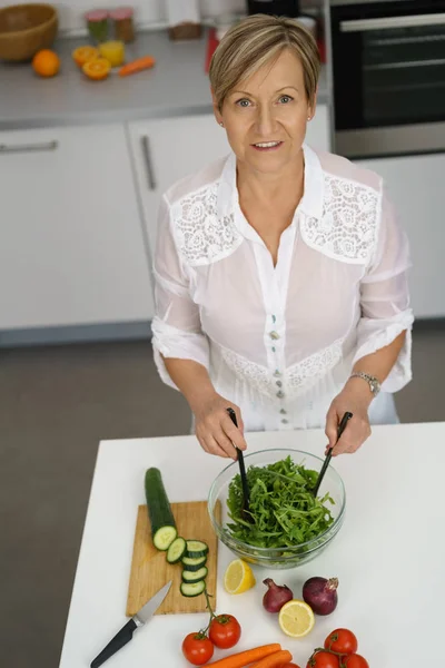 Femme âgée mélangeant la salade dans un bol — Photo