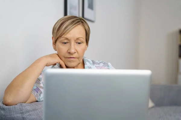 Senior kvinna som tittar på laptop skärm — Stockfoto