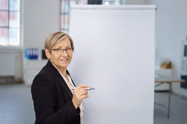 Seniorin steht vor Flipchart — Stockfoto