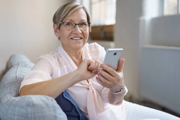 Glada senior kvinna med smartphone — Stockfoto